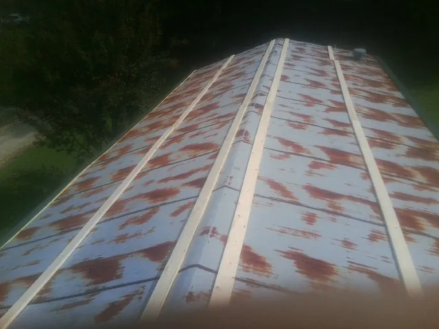 Rusted metal roof panels with new wood purlins before replacement — Storm Damage Roof Repair in Allenport by Roofing Brothers