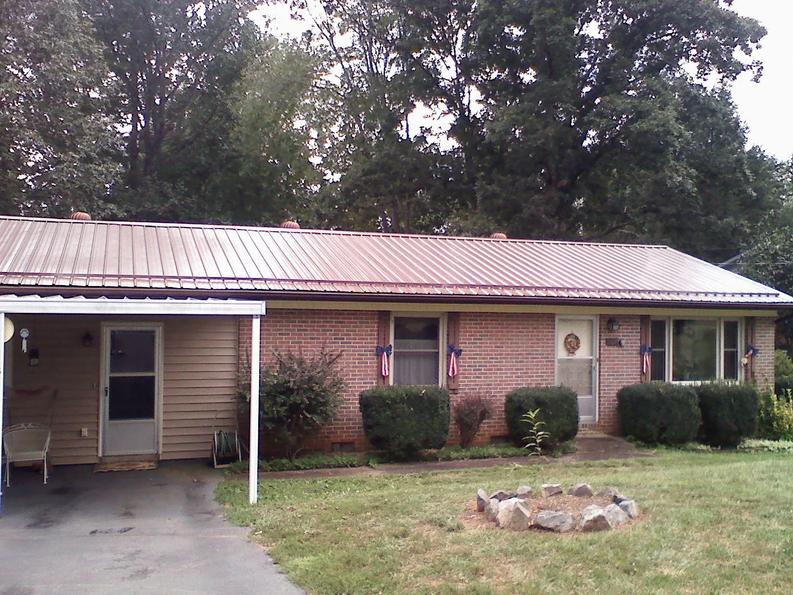 Bronze metal roof and carport on a brick ranch home — Roof Repair work by our crew in Allenport